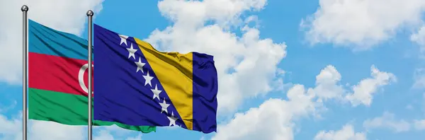 Bandera de Azerbaiyán y Bosnia Herzegovina ondeando en el viento contra el cielo azul nublado blanco juntos. Concepto diplomático, relaciones internacionales . — Foto de Stock