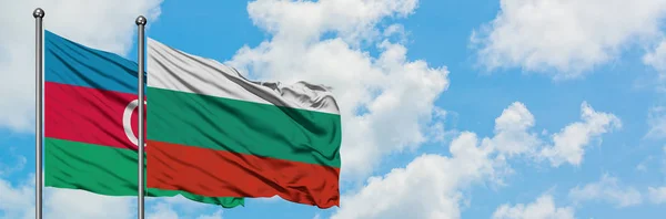 Bandera de Azerbaiyán y Bulgaria ondeando en el viento contra el cielo azul nublado blanco juntos. Concepto diplomático, relaciones internacionales . — Foto de Stock