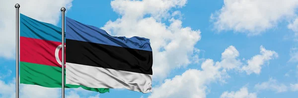 Bandera de Azerbaiyán y Estonia ondeando en el viento contra el cielo azul nublado blanco juntos. Concepto diplomático, relaciones internacionales . — Foto de Stock