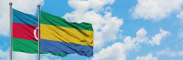 Azerbaijan and Gabon flag waving in the wind against white cloudy blue sky together. Diplomacy concept, international relations. — Stock Photo, Image