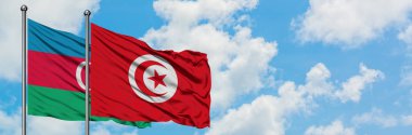Azerbaycan ve Tunus bayrağı havada havada sallayarak beyaz bulutlu mavi gökyüzüne karşı birlikte. Diplomasi kavramı, uluslararası ilişkiler.