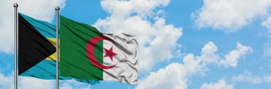 Bahamalar ve Cezayir bayrağı birlikte beyaz bulutlu mavi gökyüzüne karşı rüzgarda sallayarak. Diplomasi kavramı, uluslararası ilişkiler.