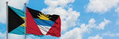Bahamalar ve Antigua ve Barbuda bayrağı birlikte beyaz bulutlu mavi gökyüzüne karşı rüzgarda sallayarak. Diplomasi kavramı, uluslararası ilişkiler.