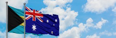 Bahamalar ve Avustralya bayrağı birlikte beyaz bulutlu mavi gökyüzüne karşı rüzgarda sallayarak. Diplomasi kavramı, uluslararası ilişkiler.