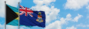 Bahamalar ve Cayman Adaları bayrağı birlikte beyaz bulutlu mavi gökyüzüne karşı rüzgarda sallayarak. Diplomasi kavramı, uluslararası ilişkiler.