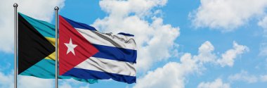 Bahamalar ve Küba bayrağı birlikte beyaz bulutlu mavi gökyüzüne karşı rüzgarda sallayarak. Diplomasi kavramı, uluslararası ilişkiler.