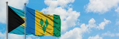 Bahamalar ve Saint Vincent ve Grenadinler bayrağı birlikte beyaz bulutlu mavi gökyüzüne karşı rüzgarda sallayarak. Diplomasi kavramı, uluslararası ilişkiler.