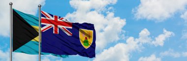 Bahamalar ve Türkler ve Caicos Adaları bayrağı birlikte beyaz bulutlu mavi gökyüzüne karşı rüzgarda sallayarak. Diplomasi kavramı, uluslararası ilişkiler.