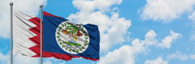 Bahreyn ve Belize bayrağı birlikte beyaz bulutlu mavi gökyüzüne karşı rüzgarda sallayarak. Diplomasi kavramı, uluslararası ilişkiler.