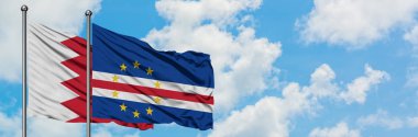 Bahreyn ve Cape Verde bayrağı birlikte beyaz bulutlu mavi gökyüzüne karşı rüzgarda sallayarak. Diplomasi kavramı, uluslararası ilişkiler.
