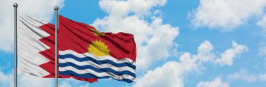 Bahreyn ve Kiribati bayrağı birlikte beyaz bulutlu mavi gökyüzüne karşı rüzgarda sallayarak. Diplomasi kavramı, uluslararası ilişkiler.