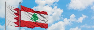 Bahreyn ve Lübnan bayrağı birlikte beyaz bulutlu mavi gökyüzüne karşı rüzgarda sallayarak. Diplomasi kavramı, uluslararası ilişkiler.
