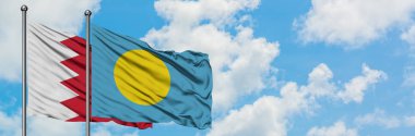 Bahreyn ve Palau bayrağı birlikte beyaz bulutlu mavi gökyüzüne karşı rüzgarda sallayarak. Diplomasi kavramı, uluslararası ilişkiler.
