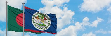 Bangladeş ve Belize bayrağı birlikte beyaz bulutlu mavi gökyüzüne karşı rüzgarda sallayarak. Diplomasi kavramı, uluslararası ilişkiler.