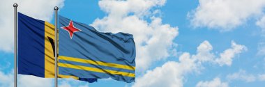 Barbados ve Aruba bayrağı birlikte beyaz bulutlu mavi gökyüzüne karşı rüzgarda sallayarak. Diplomasi kavramı, uluslararası ilişkiler.