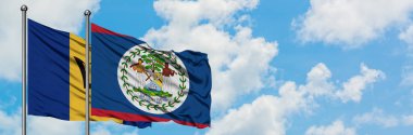 Barbados ve Belize bayrağı birlikte beyaz bulutlu mavi gökyüzüne karşı rüzgarda sallayarak. Diplomasi kavramı, uluslararası ilişkiler.