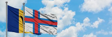 Barbados ve Faroe Adaları bayrağı birlikte beyaz bulutlu mavi gökyüzüne karşı rüzgarda sallayarak. Diplomasi kavramı, uluslararası ilişkiler.