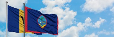 Barbados ve Guam bayrağı birlikte beyaz bulutlu mavi gökyüzüne karşı rüzgarda sallayarak. Diplomasi kavramı, uluslararası ilişkiler.