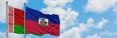 Beyaz Rusya ve Haiti bayrağı birlikte beyaz bulutlu mavi gökyüzüne karşı rüzgarda sallayarak. Diplomasi kavramı, uluslararası ilişkiler.