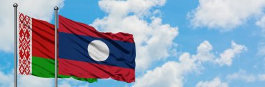 Beyaz Rusya ve Laos bayrağı birlikte beyaz bulutlu mavi gökyüzüne karşı rüzgarda sallayarak. Diplomasi kavramı, uluslararası ilişkiler.