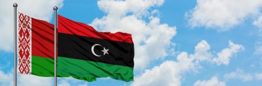 Beyaz Rusya ve Libya bayrağı birlikte beyaz bulutlu mavi gökyüzüne karşı rüzgarsal sallayarak. Diplomasi kavramı, uluslararası ilişkiler.