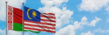 Beyaz Rusya ve Malezya bayrağı birlikte beyaz bulutlu mavi gökyüzüne karşı rüzgarda sallayarak. Diplomasi kavramı, uluslararası ilişkiler.