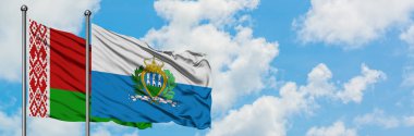 Beyaz Rusya ve San Marino bayrağı birlikte beyaz bulutlu mavi gökyüzüne karşı rüzgarda sallayarak. Diplomasi kavramı, uluslararası ilişkiler.