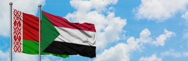 Beyaz Rusya ve Sudan bayrağı birlikte beyaz bulutlu mavi gökyüzüne karşı rüzgarsal sallayarak. Diplomasi kavramı, uluslararası ilişkiler.