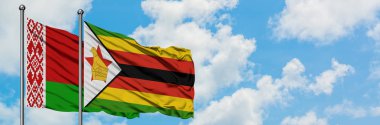 Beyaz Rusya ve Zimbabve bayrağı birlikte beyaz bulutlu mavi gökyüzüne karşı rüzgarda sallayarak. Diplomasi kavramı, uluslararası ilişkiler.