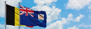 Belçika ve Anguilla bayrağı birlikte beyaz bulutlu mavi gökyüzüne karşı rüzgarda sallayarak. Diplomasi kavramı, uluslararası ilişkiler.