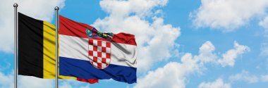 Belçika ve Hırvatistan bayrağı birlikte beyaz bulutlu mavi gökyüzüne karşı rüzgarda sallayarak. Diplomasi kavramı, uluslararası ilişkiler.