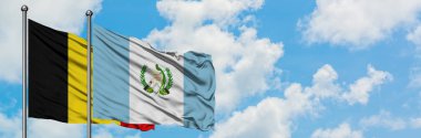 Belçika ve Guatemala bayrağı birlikte beyaz bulutlu mavi gökyüzüne karşı rüzgarsal sallayarak. Diplomasi kavramı, uluslararası ilişkiler.