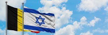 Belçika ve İsrail bayrağı birlikte beyaz bulutlu mavi gökyüzüne karşı rüzgarda sallayarak. Diplomasi kavramı, uluslararası ilişkiler.