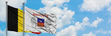 Belçika ve Mayotte bayrağı birlikte beyaz bulutlu mavi gökyüzüne karşı rüzgarda sallayarak. Diplomasi kavramı, uluslararası ilişkiler.