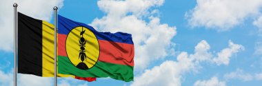 Belçika ve Yeni Kaledonya bayrağı birlikte beyaz bulutlu mavi gökyüzüne karşı rüzgarda sallayarak. Diplomasi kavramı, uluslararası ilişkiler.