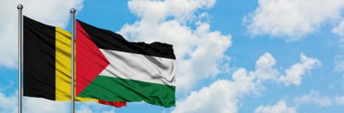 Belçika ve Filistin bayrağı birlikte beyaz bulutlu mavi gökyüzüne karşı rüzgarda sallayarak. Diplomasi kavramı, uluslararası ilişkiler.