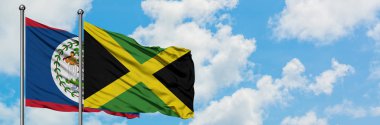 Belize ve Jamaika bayrağı birlikte beyaz bulutlu mavi gökyüzüne karşı rüzgarda sallayarak. Diplomasi kavramı, uluslararası ilişkiler.