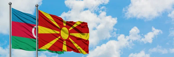 Azerbaijão e Macedônia bandeira acenando no vento contra o céu azul nublado branco juntos. Conceito de diplomacia, relações internacionais . — Fotografia de Stock