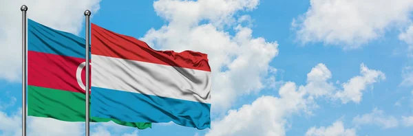 Azerbajdzsán és Luxemburg lobogója integetett a szél ellen, fehér felhős kék eget együtt. Diplomáciai koncepció, nemzetközi kapcsolatok. — Stock Fotó