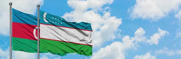 Azerbaigian e Uzbekistan sventolano insieme la bandiera contro il bianco cielo azzurro nuvoloso. Concetto di diplomazia, relazioni internazionali . — Foto Stock