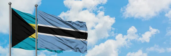 Bahamas and Botswana flag waving in the wind against white cloudy blue sky together. Diplomacy concept, international relations. — Stock Photo, Image