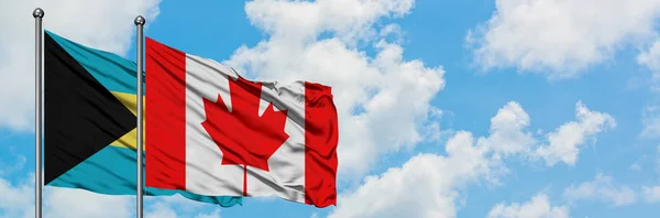 Bandera de Bahamas y Canadá ondeando en el viento contra el cielo azul nublado blanco juntos. Concepto diplomático, relaciones internacionales . — Foto de Stock