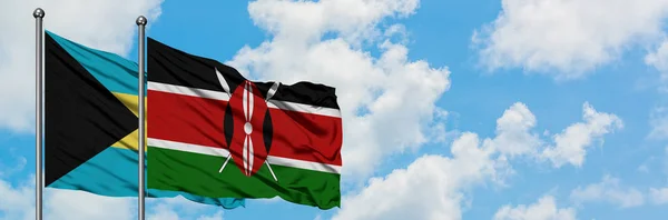 Bandera de Bahamas y Kenia ondeando en el viento contra el cielo azul nublado blanco juntos. Concepto diplomático, relaciones internacionales . —  Fotos de Stock