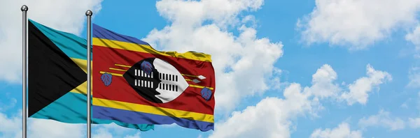 Bahamas and Swaziland flag waving in the wind against white cloudy blue sky together. Diplomacy concept, international relations. — Stock Photo, Image