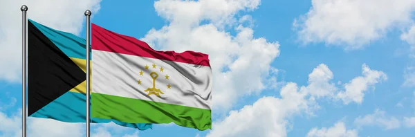 Bahamas and Tajikistan flag waving in the wind against white cloudy blue sky together. Diplomacy concept, international relations. — Stock Photo, Image