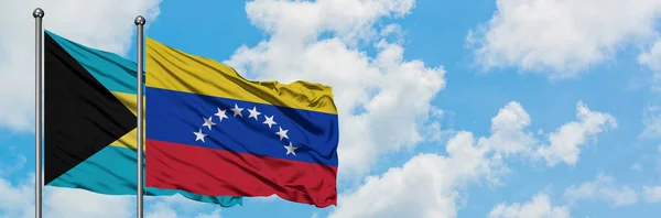 Bahamas and Venezuela flag waving in the wind against white cloudy blue sky together. Diplomacy concept, international relations. — Stock Photo, Image
