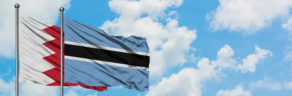 Bahrain and Botswana flag waving in the wind against white cloudy blue sky together. Diplomacy concept, international relations. — Stock Photo, Image