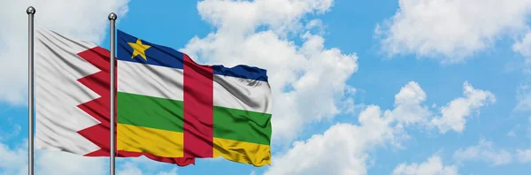 Bandera de Bahréin y República Centroafricana ondeando en el viento contra el cielo azul nublado blanco juntos. Concepto diplomático, relaciones internacionales . — Foto de Stock