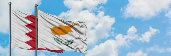 Bandera de Bahréin y Chipre ondeando en el viento contra el cielo azul nublado blanco juntos. Concepto diplomático, relaciones internacionales . — Foto de Stock