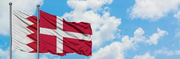 一緒に白い曇り青い空に対して風に手を振るバーレーンとデンマークの旗。外交概念、国際関係. — ストック写真